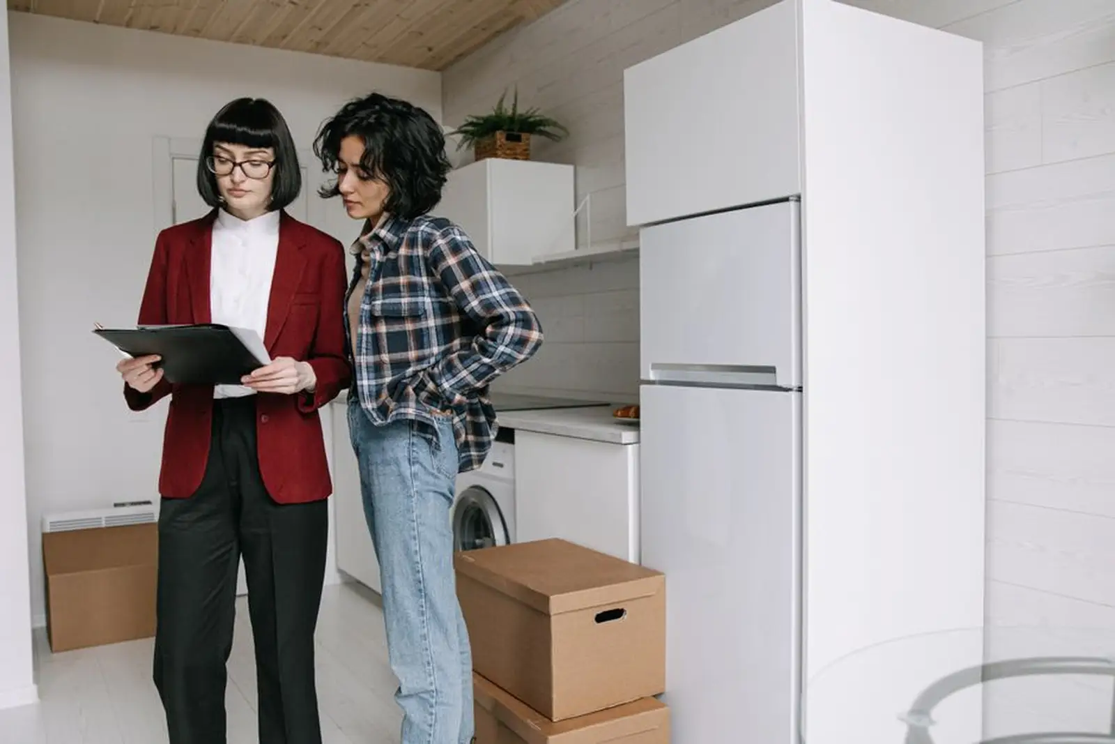 Trois colocataires discutent autour d'un canapé, un contrat d'assurance habitation posé sur la table basse